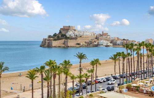 a view of a beach with palm trees and a city at Euromar Ii in Peñíscola