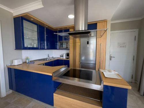 a kitchen with blue cabinets and a stainless steel refrigerator at Holiday Club Vista Amadores in Amadores