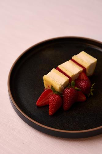 a black plate with cheese and strawberries on it at Relais La Corte dei Papi in Cortona
