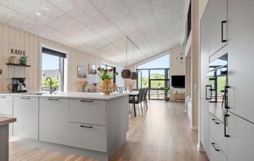a kitchen with white cabinets and a dining room at Gorgeous Home In Haderslev in Haderslev