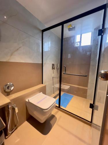 a bathroom with a toilet and a shower at Hotel Grand Pragati in Surat