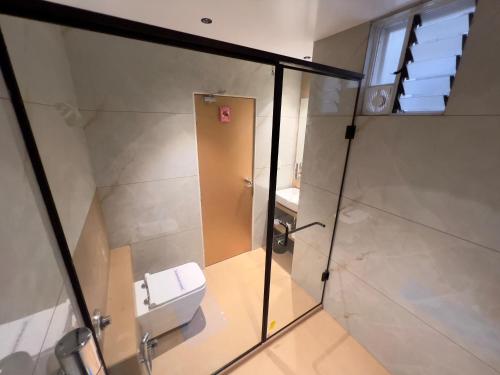 a small bathroom with a shower and a toilet at Hotel Grand Pragati in Surat