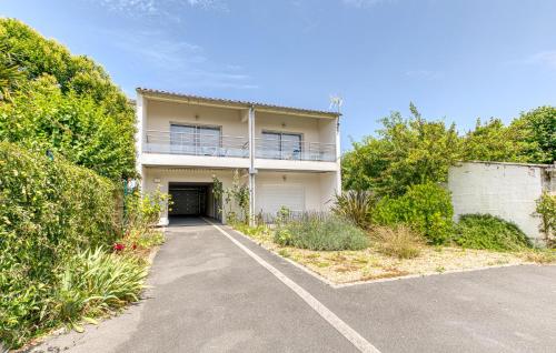 une maison blanche avec un garage et une allée dans l'établissement Appartement Proche Plage, à La Rochelle