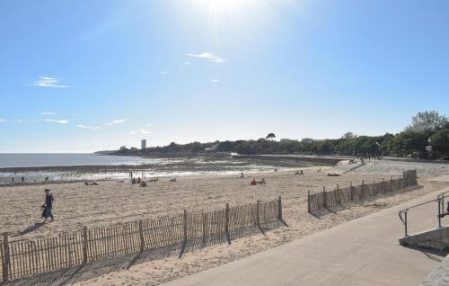 un groupe de personnes sur une plage près de l'océan dans l'établissement Appartement Proche Plage, à La Rochelle