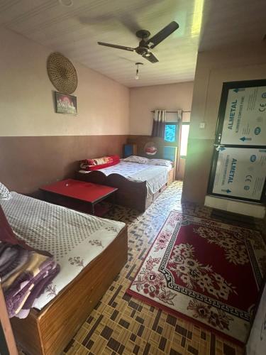 a bedroom with two beds and a couch in it at Darshan Namaste Restaurant and Cocktail Bar in Meghauli