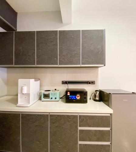 a kitchen with a counter with a toaster and a microwave at Studio with Rooftop Pool at Youth City Nilai by D'KAY HOMES, near USIM KLIA in Nilai