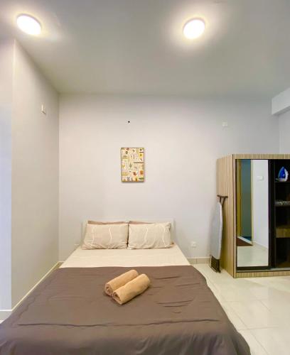 a bedroom with a bed with a towel on it at Studio with Rooftop Pool at Youth City Nilai by D'KAY HOMES, near USIM KLIA in Nilai