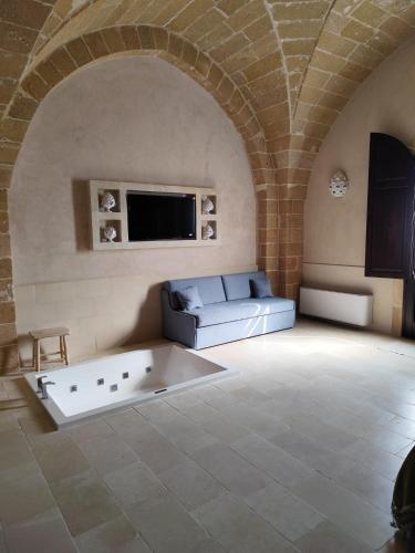 a living room with a couch and a tv at Borgo Don Ciccio in Felline