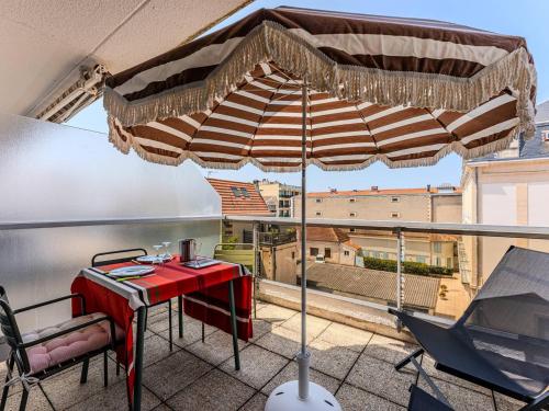 - un parasol sur un balcon avec une table et des chaises dans l'établissement Studio Vintage Rénové à Arcachon, Plage et Jetée Thiers à Proximité - FR-1-433-143, à Arcachon