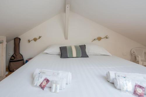 un lit blanc avec deux oreillers dessus dans l'établissement MARGUERITE - Wifi - Parking, à Pornichet