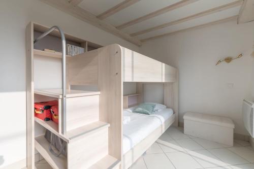 Ce lit superposé blanc se trouve dans une chambre blanche. dans l'établissement MARGUERITE - Wifi - Parking, à Pornichet