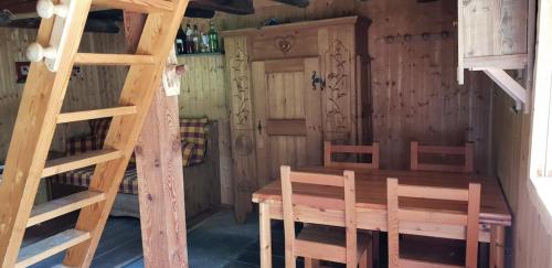 une chambre avec une table et des chaises en bois ainsi qu'une échelle dans l'établissement Alpine Chalet 1800m le Petit Fontcouverte Névache, à Névache