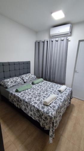 a bedroom with a bed with two pillows on it at Aconchego no Centro da Cidade in Paulo Afonso