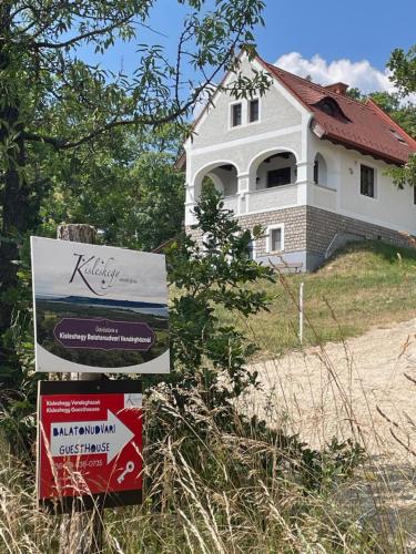 a house with a sign in front of it at Kisleshegy Balatonudvari Vendégház in Balatonudvari