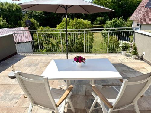 a white table and two chairs and an umbrella at Fewo Linz in Frensdorf