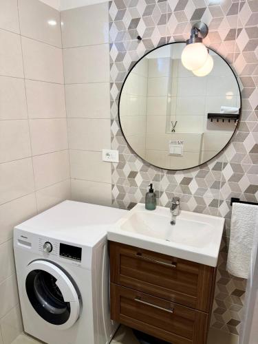 a bathroom with a washing machine and a sink at M Plus Residence in Pinezici