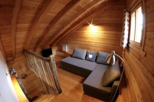 a living room in a log cabin with a couch at Au Vialaou - Chez Marcelle in Névache