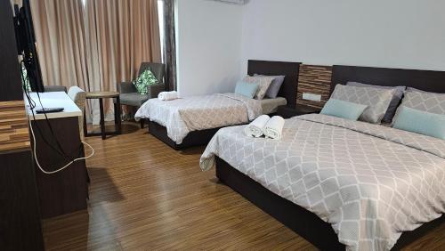 a hotel room with two beds and a television at KITA Studio - Kota Bharu City Point in Kota Bharu