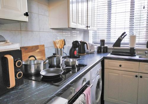 a kitchen with a stove with pots and pans on it at Spacious Apartment -Double and Sofabed -Wonderful Royal Pavilion Views in Brighton & Hove