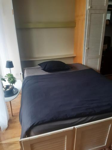 - un lit avec une couverture bleue dans une chambre dans l'établissement Vue mer panoramique et plage à 50 m, à Bénodet