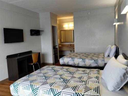a hotel room with two beds and a desk at Motel 6-Seaford, DE in Seaford