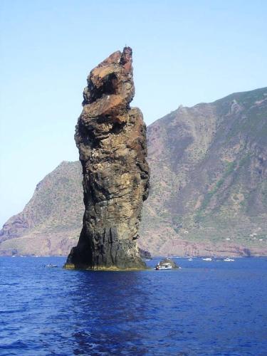 a rock formation in the middle of a body of water at CasaEolia Golden in Canneto