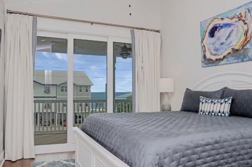 a bedroom with a large bed and a balcony at Port St Paradise by Pristine Properties Vacation Rentals in Saint Joe Beach