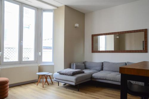 Una sala de estar con un sofá y un espejo. en T2, Centre ville, Gare 600m, Prox Lille, Terrasse, en Tourcoing