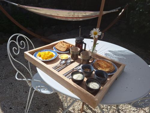 een tafel met een dienblad met ontbijtproducten erop bij Lou Montadou in Yssingeaux