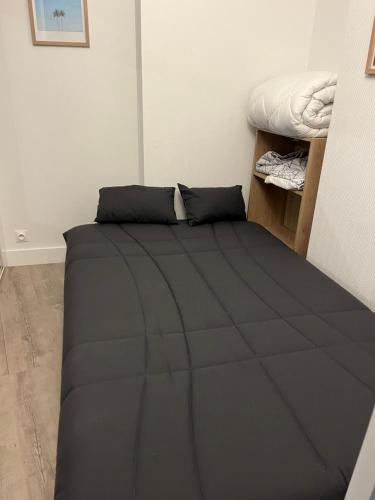 - une chambre avec un lit et une couette noire dans l'établissement Horizon Bleu : Appartement Vue Mer à La Baule, à La Baule