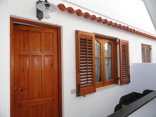 a house with a wooden door and windows at CasaEolia Golden in Canneto