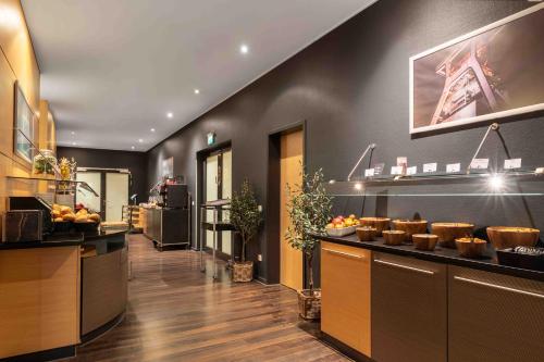 a restaurant with a counter with fruits on it at Ramada by Wyndham Essen in Essen