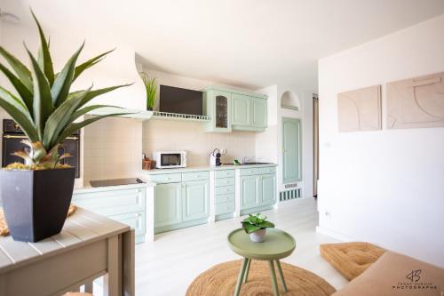 une cuisine avec des armoires bleues et une plante en pot dans l'établissement L'Athlantis - Cosy with terrace and parking, à Saint-Cyprien