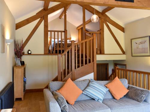 a living room with a couch and a staircase at Hilltoft Barn in Dockray