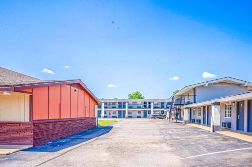 a row of buildings in a parking lot at Deluxe Inn & Suites By OYO Miami OK in Miami