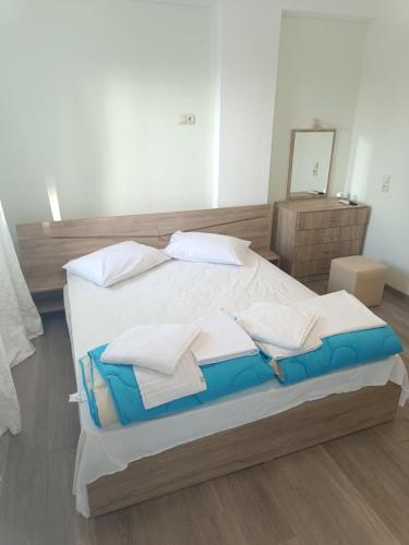 a large bed with white sheets and pillows on it at Oasis luxury apartments in Monastirákion