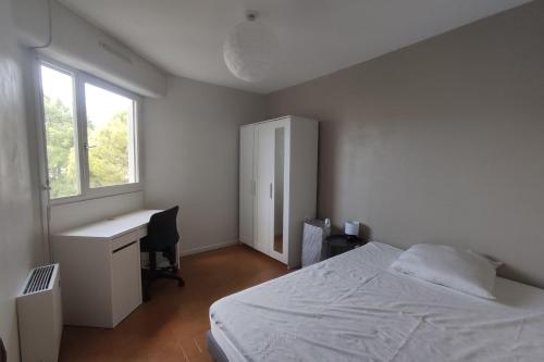 une chambre avec un lit, un bureau et une fenêtre dans l'établissement Family apartment for 10 people with balcony, à Montpellier