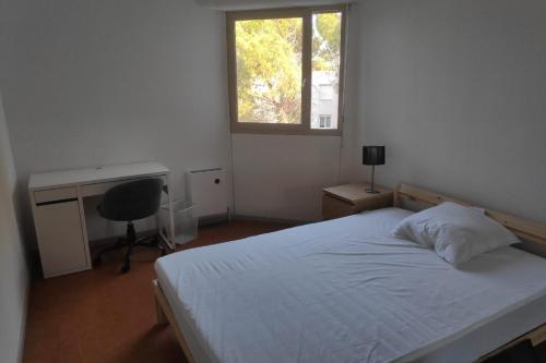 une chambre avec un lit, un bureau et une fenêtre dans l'établissement Family apartment for 10 people with balcony, à Montpellier
