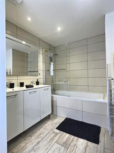 une salle de bain blanche avec une baignoire et un lavabo dans l'établissement L'Entre Deux Miss K Conciergerie, à Mâcon