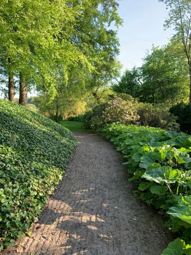 a path through a park with a bunch of plants at Artistic Gardener's House At Kollerup Estate in Hadsten Stationsby