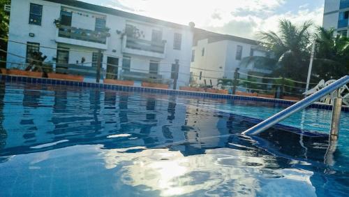 a swimming pool in front of a building at Apto Beira Mar - Morada das Ondas in Paulista