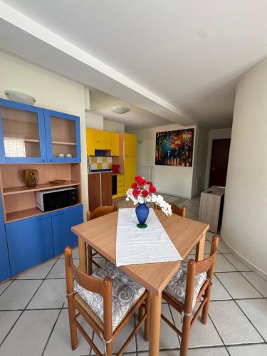 a kitchen with a wooden table with a vase of flowers on it at Bisco' B&B in Nuoro
