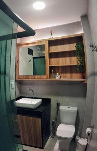 a bathroom with a white toilet and a sink at Apto Beira Mar - Morada das Ondas in Paulista