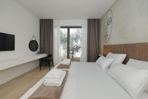 a white bedroom with two beds and a tv at Cloud 9 D10 in Tkon