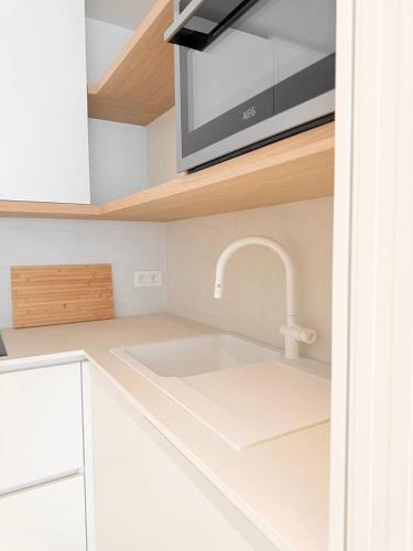 a kitchen with a sink and a microwave at Studio Nacre Knokke in Knokke-Heist