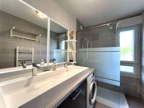 une salle de bain avec un grand lavabo et un miroir dans l'établissement Appartement 3 pièces avec jardin privatif - La Baule Centre - FR-1-245-102, à La Baule