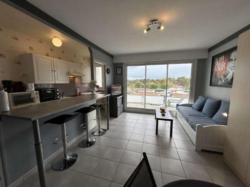 une cuisine et un salon avec un canapé dans l'établissement Studio cabine 4 pers. avec balcon et parking, proche plage - FR-1-224C-176, à Saint-Jean-de-Monts