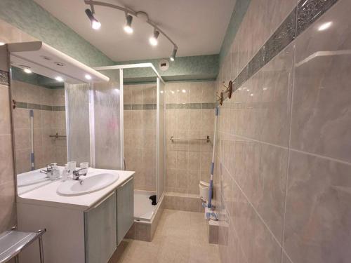 une salle de bain avec un lavabo et une douche dans l'établissement Appartement 3ème étage face mer avec balcon, ascenseur et parking privatif - FR-1-672-1, à Merlimont