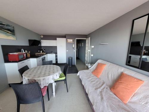 un salon avec un canapé et une table dans l'établissement Appartement 3ème étage face mer avec balcon, ascenseur et parking privatif - FR-1-672-1, à Merlimont