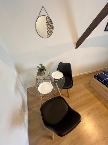 a dining room with a glass table and two chairs at Charme & calme en Centre ville à pied avec parking gratuit - Studio Oslo in Châtellerault